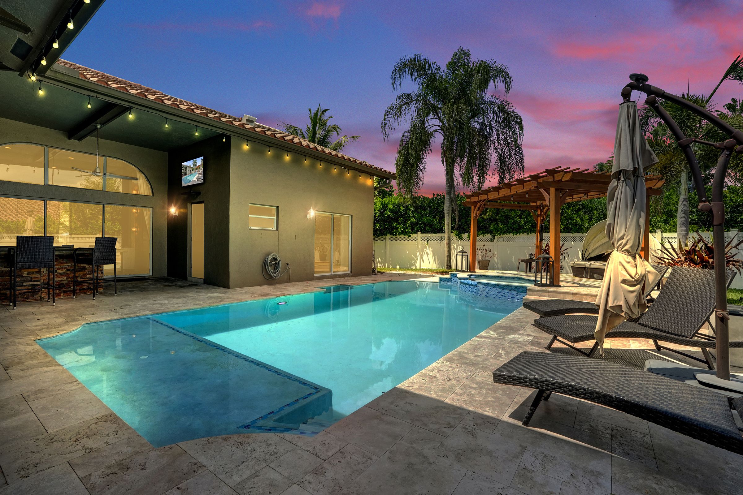 Private pool and pergola at dusk at a South Florida pool home